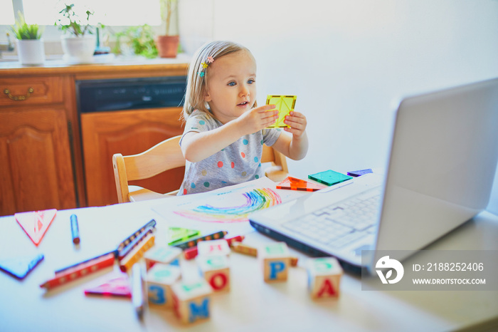 Toddler girl learning shapes in front of laptop