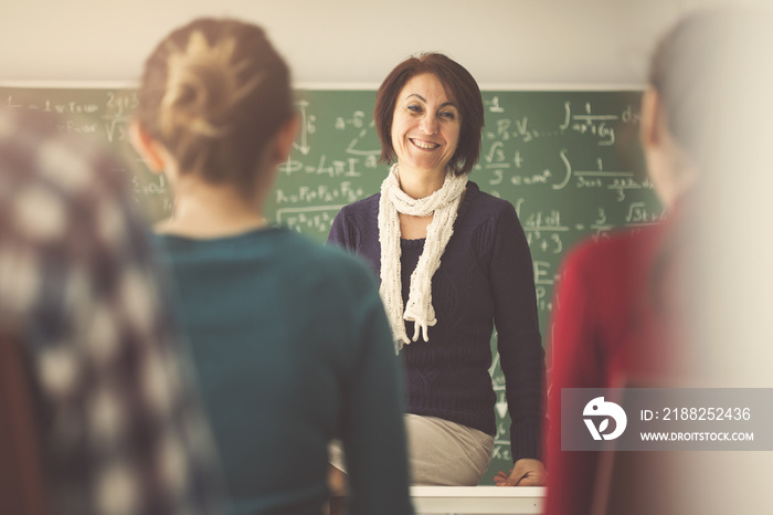 Teacher giving lesson to students in  classroom