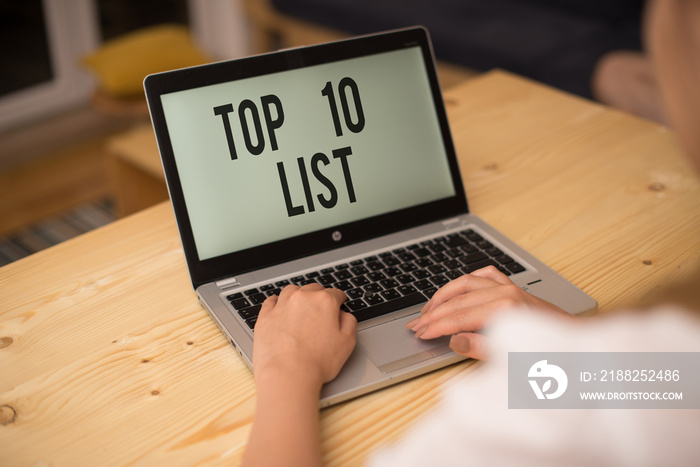 Writing note showing Top 10 List. Business concept for the ten most important or successful items in a particular list woman with laptop smartphone and office supplies technology