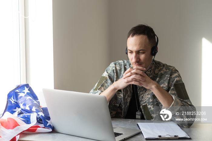 Soldier working with laptop in headquarters building