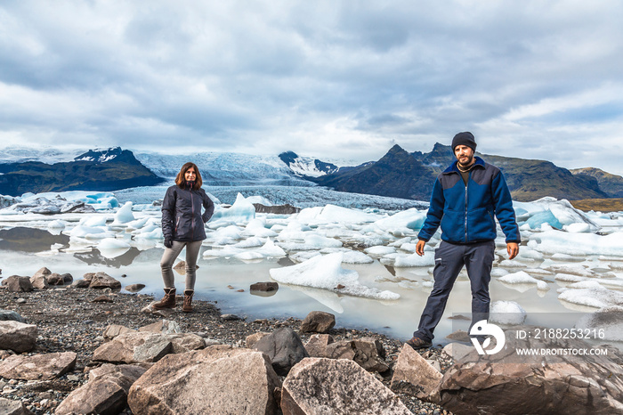 A couple at the Jokulsarlon icebergs lake in the golden circle of southern Iceland