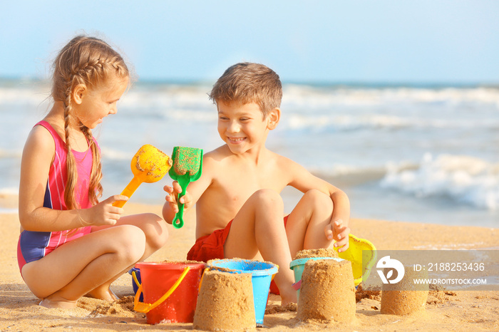 Cute children playing with sand on sea beach