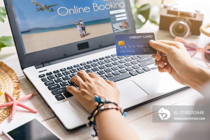 Young women planning summer vacation trip and searching information or booking hotel and using credit card on laptop, Travel concept