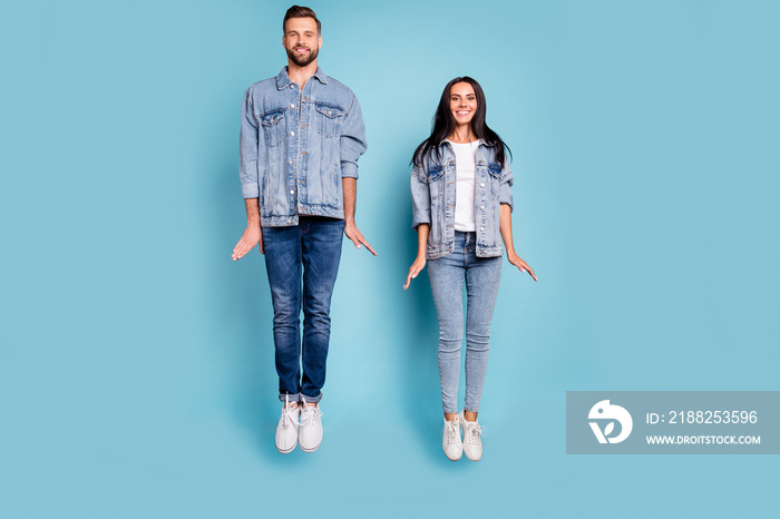 Full length body size photo of rejoicing enjoying nice cute couple of spouses frozen in air while isolated with blue background