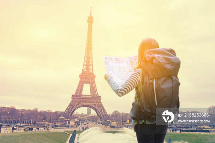 travel and people concept ,Back of travel woman in Paris ,France, with Eiffel Tower looking a map and city guide over eifel and vintage sky background in the morning