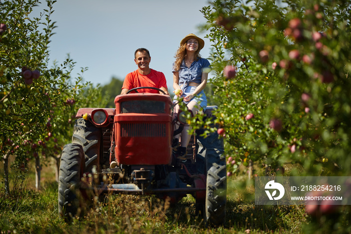 Farmers couple driving tractor