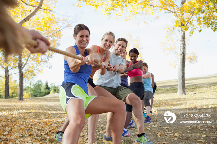 Group of people in tug of war outdoors.