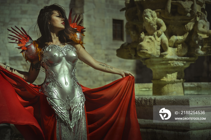 Royal Queen in silver and gold armor, beautiful brunette woman with long red coat and brown hair