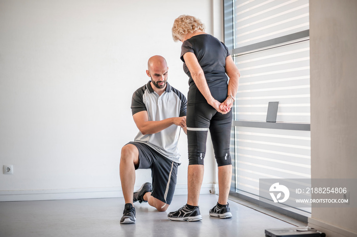 Personal trainer evaluating health of elderly fit woman