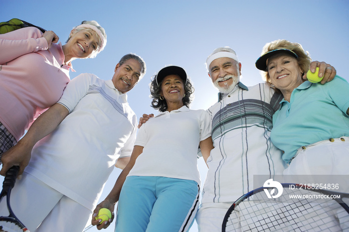 Diverse group of senior tennis players against clear sky