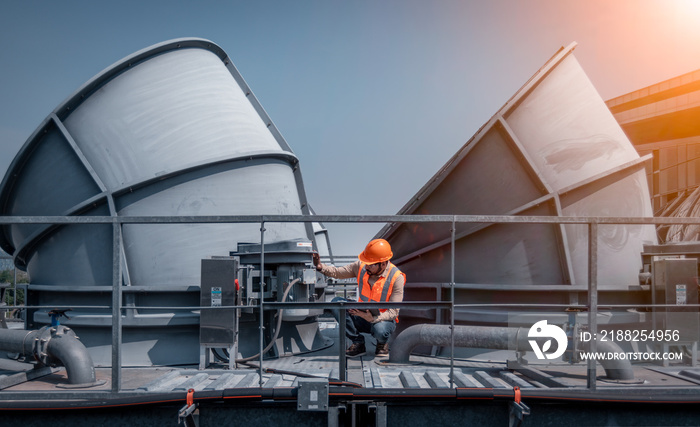 engineer under checking the industry cooling tower air conditioner is water cooling tower air chiller HVAC of large industrial building to control air system.