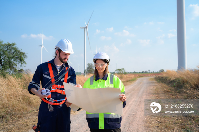 Man and female engineer stationed at the Natural Energy Wind Turbine site. with daily audit tasks of major wind turbine operations that transform wind energy into electrical electricity