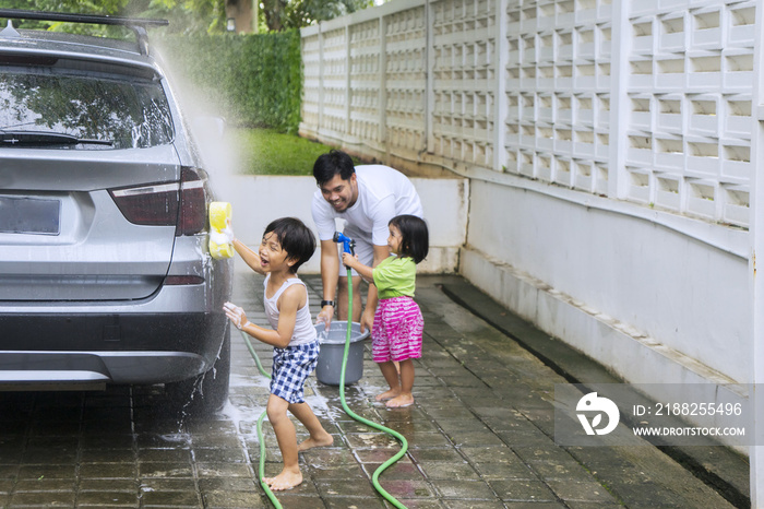 Children and father washing a car