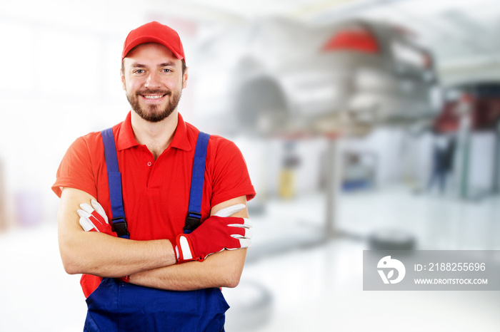 happy auto mechanic standing in car service garage