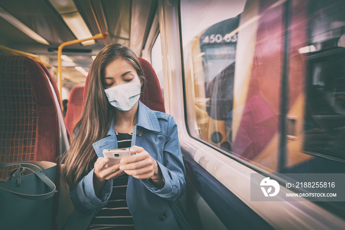 Mask wearing mandatory inside public spaces for transport such as train station and bus. Asian woman passenger using mobile phone with face covering wear sitting indoors on commute.