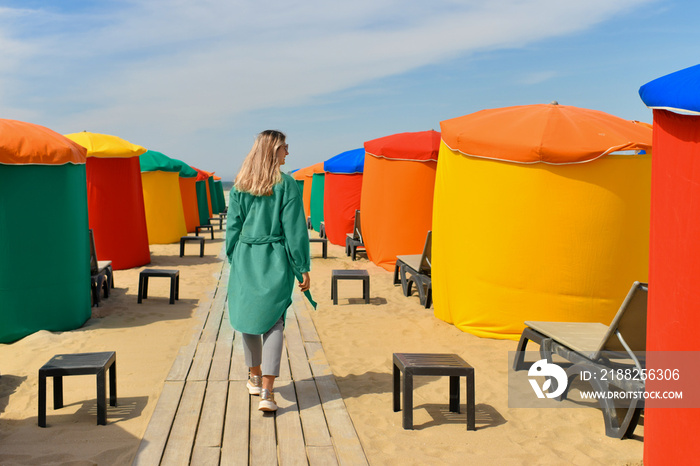 A woman near the typical tents and beach chairs