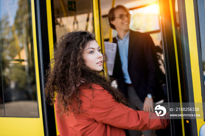 Young woman entering bus