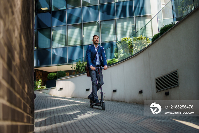 Young business man in a suit riding an electric scooter on a business meeting. Ecological transportation concept