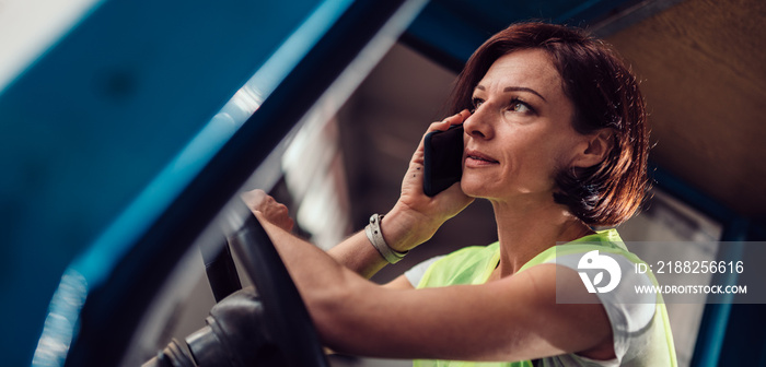 Woman forklift operator talking on the phone in vehicle