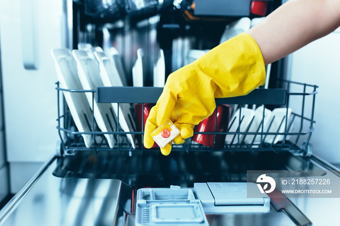 Close up of woman’s hand holding dishwasher soap tablet.