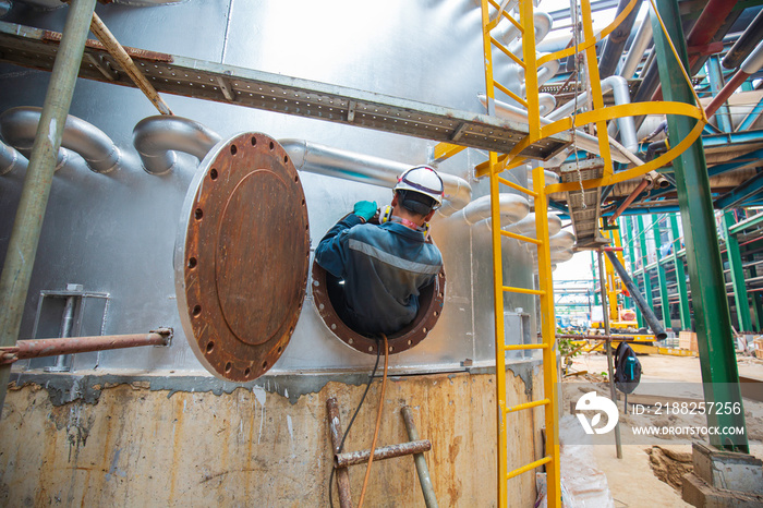 Male worker into the tank carbon chemical oil interface area confined