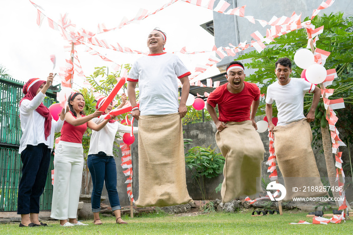 three sacks races tried to jump and run with supporting spectators on Indonesia’s independence day celebrations on the field with balloons and small red and white decorations.