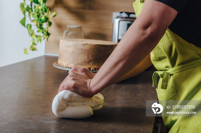 Unrecognisable woman preparing white fondant for cake decorating, hands detail. DIY, sequence, step by step, part of series.