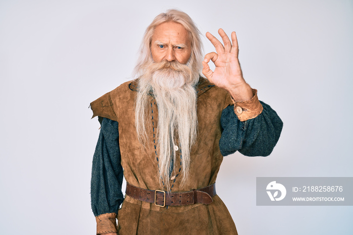 Old senior man with grey hair and long beard wearing viking traditional costume smiling positive doing ok sign with hand and fingers. successful expression.