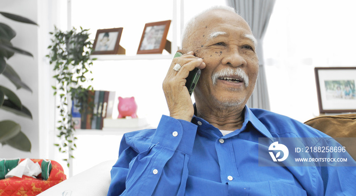 Asian Senior man with white mustache talking with smart phone.