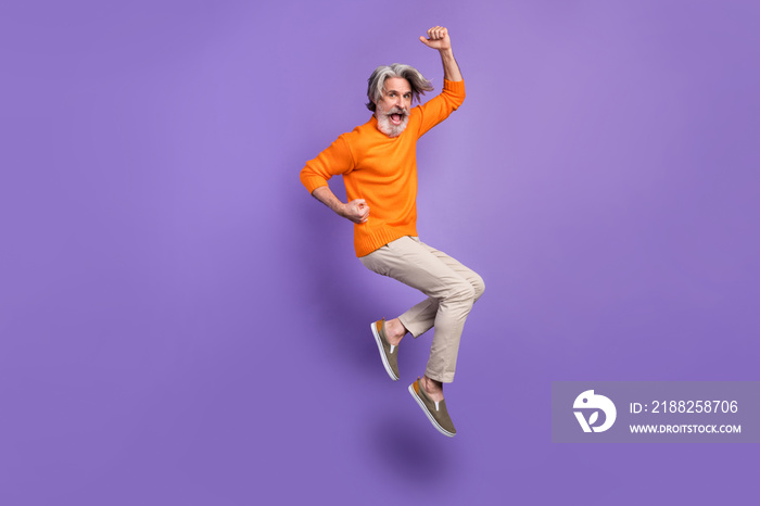 Full size profile side photo of aged man rejoice win victory jump up happy positive smile isolated over purple color background