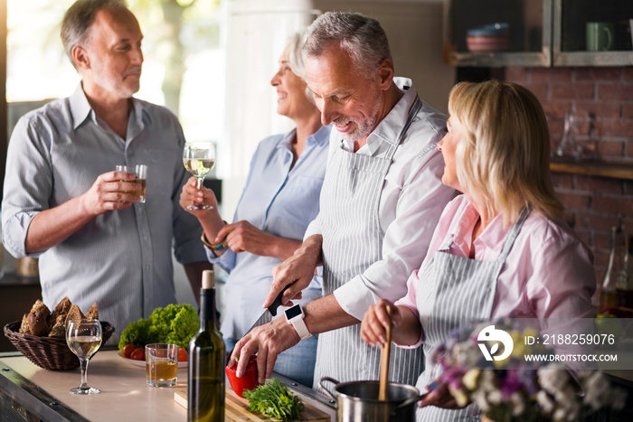 Mature friends having fun while making dinner