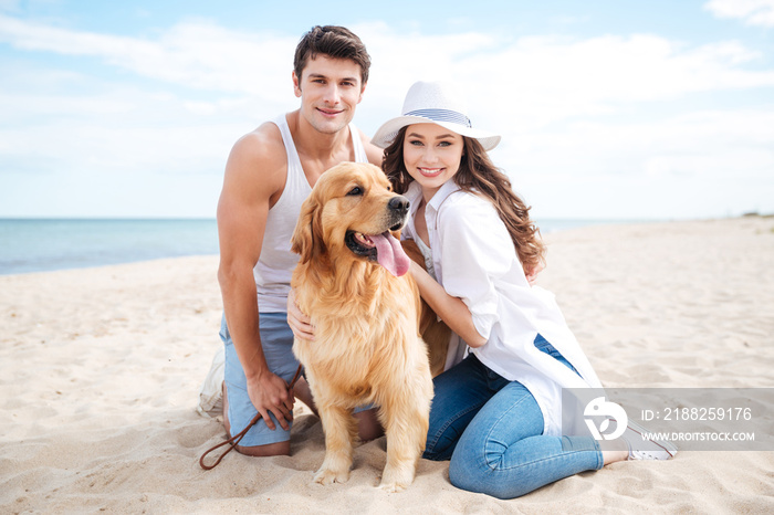 Couple with their dog on the beach in summer