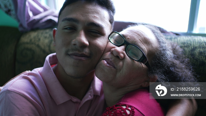 Grandmother and grandson cheek to cheek portrait looking at camera embrace and love