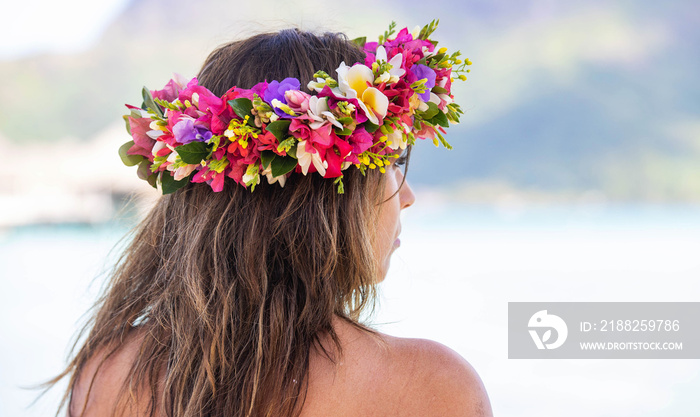 Beautiful woman wearing colorful flower crown while on a tropical island vacation in Bora Bora near Tahiti in French Polynesia