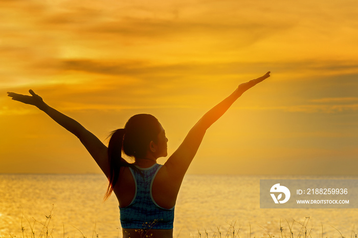 Silhouette healthy woman lifestyle relaxing and exercising vital meditate and practicing yoga on the beach at sunset.  Healthy Concept..