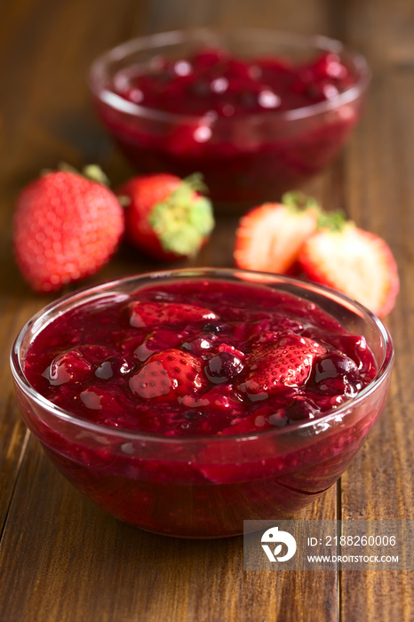 Rote Grütze aus Erdbeeren, Blaubeeren, rote Johannisbeeren and Himbeeren, fotografiert mit natürlichem Licht (Selektiver Fokus, Fokus ein Drittel in die erste Grütze)