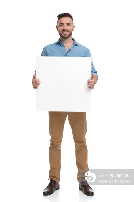 casual man standing with billboard on hands happy