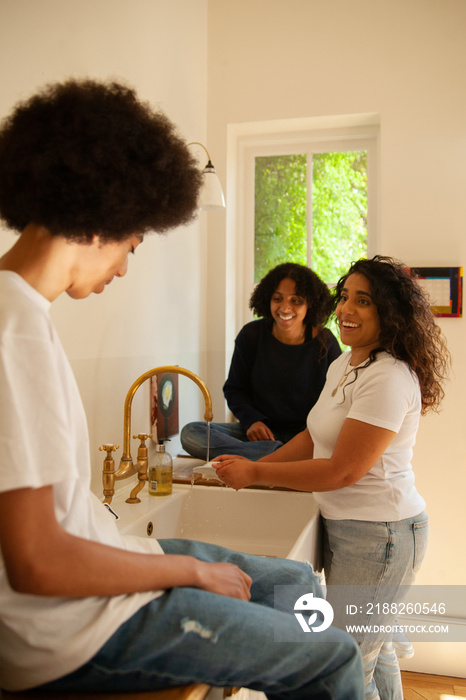 Mid-sized mother having fun with her children in the kitchen