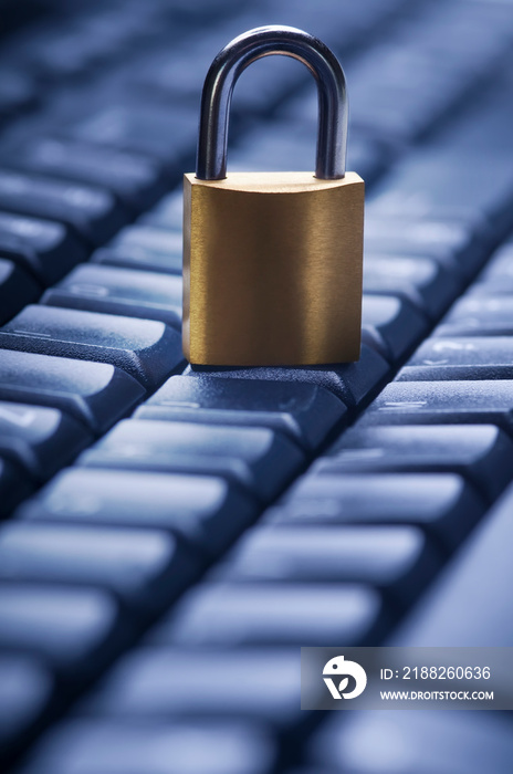 Locked metal padlock on blue computer keyboard. Data and password protection, internet and network security concept