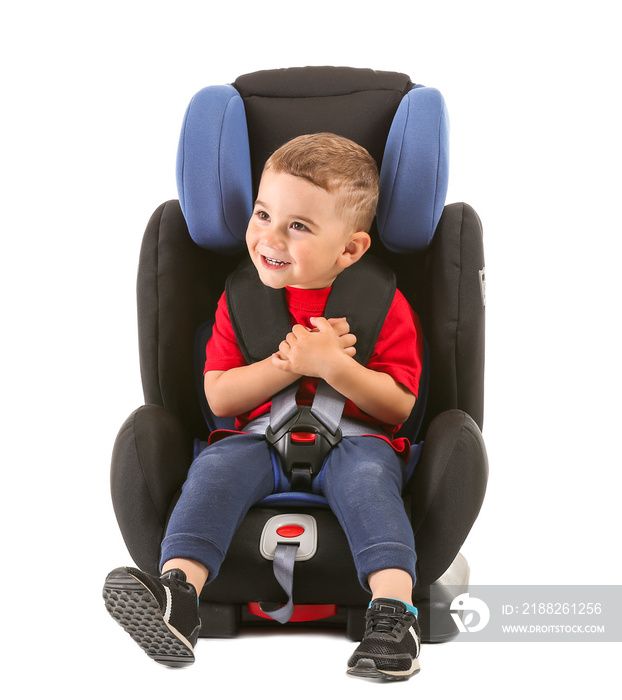 Little boy buckled in car seat on white background