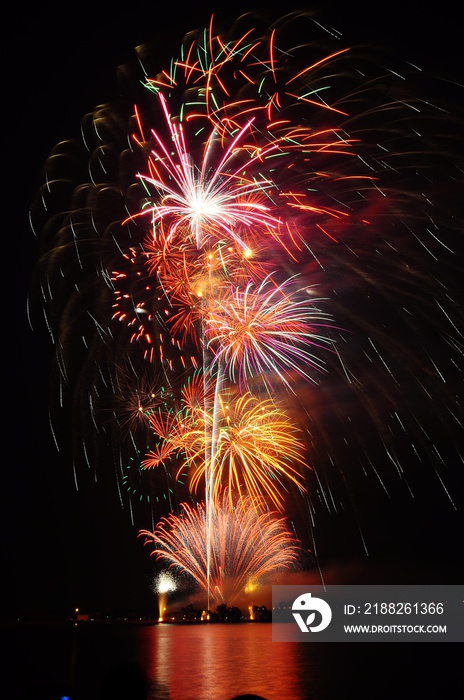 Fireworks light up the sky over river. Copy space.