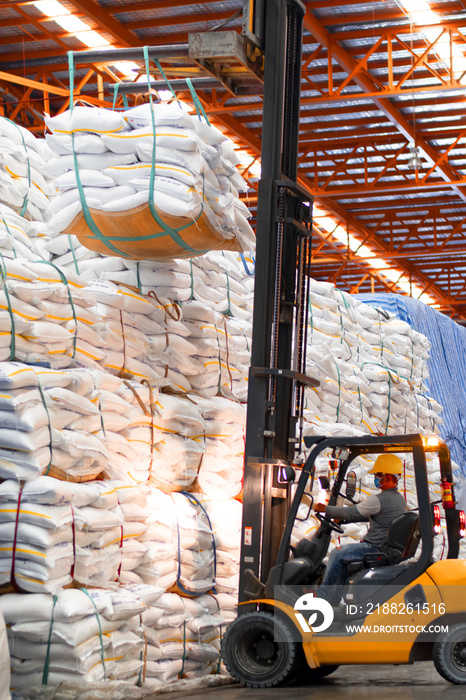 Vertical view of forklift lift jumbo bag of sugar stacking inside a warehouse. Food logistics.