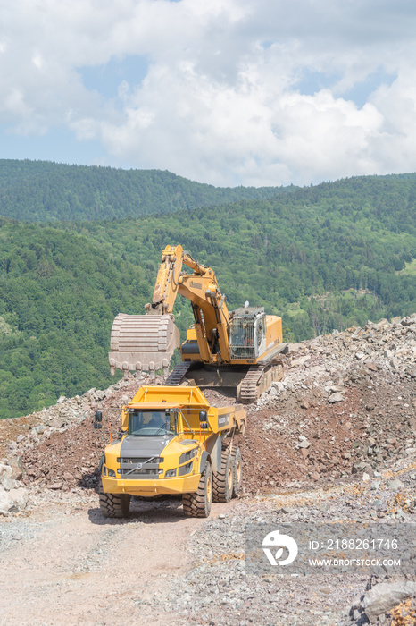 Large dump truck. Loading the rock into the bucket. Loading coal into a body truck. Production of useful minerals. Truck mining machinery for transporting coal from open pit excavation works
