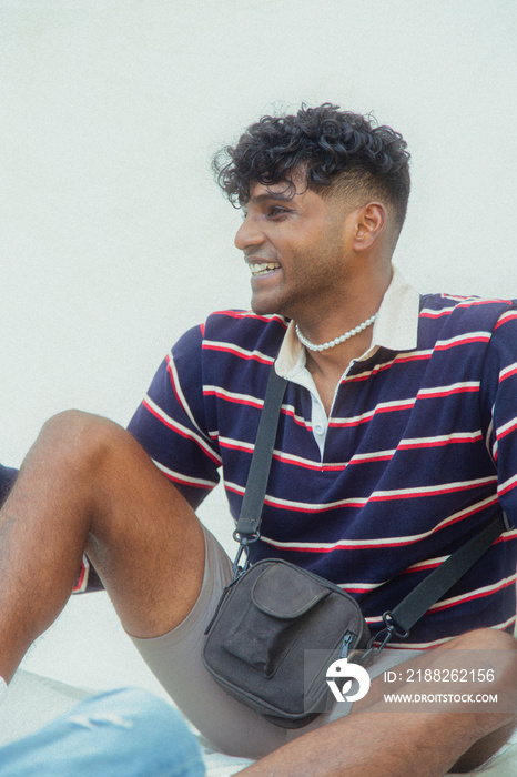 Malaysian Indian men posing and laughing together in a group setting, outdoors, in a park against a cloth backdrop