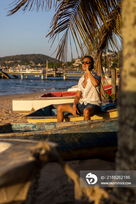 Man sitting at beach and using smart phone