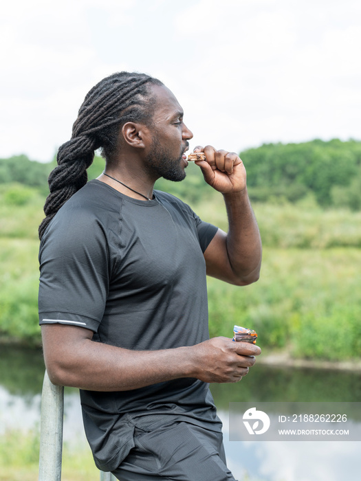 Man eating protein bar during workout