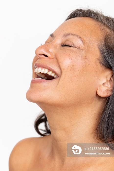 Studio portrait of smiling woman with eyes closed