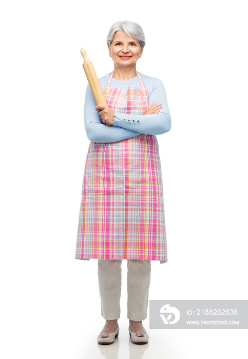 cooking, culinary and old people concept - smiling senior woman in kitchen apron with rolling pin over white background