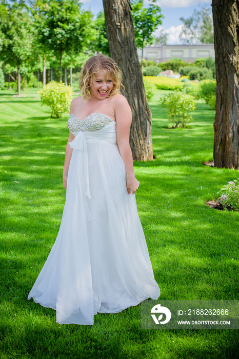 Beautiful plus size bride at park in her wedding. Wedding concept