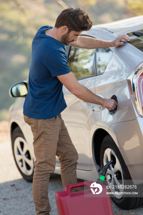 Man filling car gas tank at roadside